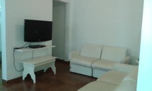 a living room with a couch and a tv at Residencial flat Golden beach.. in Guarujá