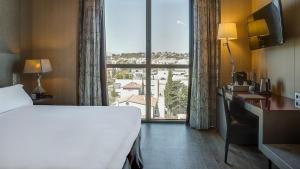 Habitación de hotel con cama y ventana grande en Hotel MiM Sitges & Spa, en Sitges