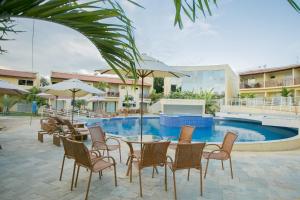 a patio with chairs and a table and a pool at Solar Agua in Pipa