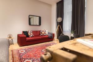 ブダペストにあるTG Hotel Apartments Budapestのリビングルーム(赤いソファ、鏡付)
