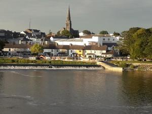 a view of a town with a river and a church at Shannonside Studios in Athlone