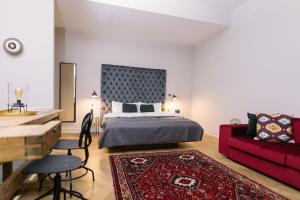 ブダペストにあるTG Hotel Apartments Budapestのベッドルーム1室(ベッド1台、赤いソファ付)