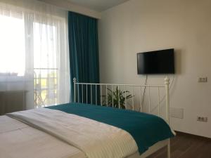 Un dormitorio con una cama con un televisor en la pared. en Pipera Lake View by ACME RENT, en Bucarest