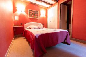 a bedroom with a bed in a red room at Hôtel Restaurant Du PONT D'ABENSE in Tardets-Sorholus