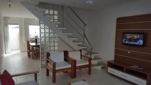 uma sala de estar com uma escada e uma mesa e cadeiras em Condomínio Mar da Galiléia - Apto 27 em Porto Seguro