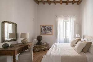 a bedroom with a bed and a desk and a mirror at Dimora Botteghelle in Trapani