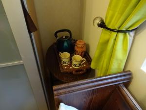 a table with two cups and a tea kettle at Victorian Gate House Own Bathroom in Solihull