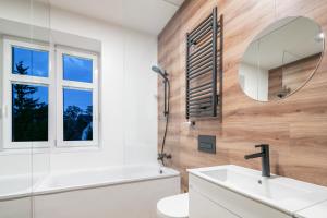 Un baño con un lavabo blanco y un espejo. en Pytloun Flat Hotel, en Liberec