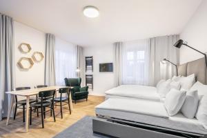 Una habitación de hotel con una cama, una mesa y sillas. en Pytloun Flat Hotel, en Liberec