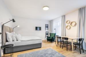 1 dormitorio con 1 cama, mesa y sillas en Pytloun Flat Hotel, en Liberec
