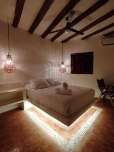 a bedroom with a large bed with two pendant lights at Casa Mech in Holbox Island