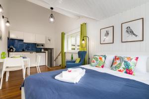 1 Schlafzimmer mit einem blauen und weißen Bett und einer Küche in der Unterkunft Mokotów Cosy House Studio in Warschau