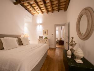 1 dormitorio con 1 cama blanca grande y espejo en Dimora Botteghelle, en Trapani