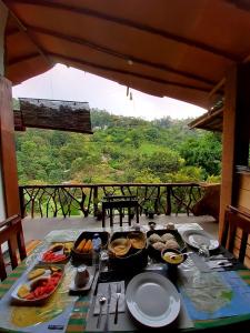 a table with food on it with a view at NatureWoodland in Ella