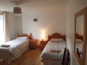 a bedroom with two beds and a mirror at Telford Road Apartment in Inverness