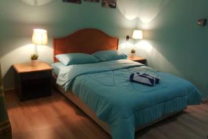 1 dormitorio con 1 cama con manta azul y 2 lámparas en Seri Bulan Apartment Teluk Kemang, en Port Dickson