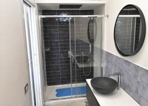 a bathroom with a shower with a sink and a mirror at Calise Guest house in Procida