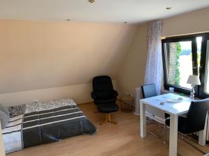 a bedroom with a bed and a desk and a chair at Ferienwohnung am Bramschebach in Löhne