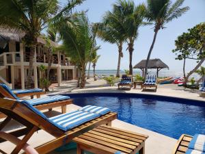 a resort swimming pool with chairs and palm trees at CASA TORTUGA, Soliman Bay in Tulum