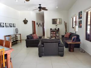 a living room with couches and a ceiling fan at CASA TORTUGA, Soliman Bay in Tulum