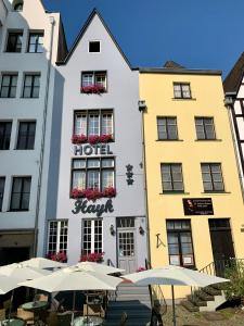un hotel con sombrillas frente a un edificio en Altstadthotel Hayk am Rhein, en Colonia