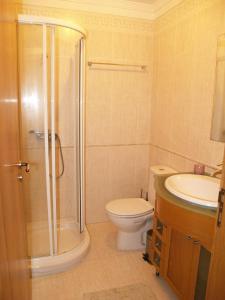 een badkamer met een douche, een toilet en een wastafel bij Cabedelo guest house in Viana do Castelo