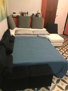 Cama grande en habitación con manta azul en Jeans Luxury House en Génova