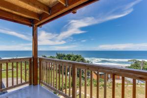 a view of the beach from the deck of a beach house at The Whale at Sandstone Point in Lincoln City