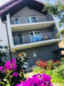a building with a balcony and flowers in front of it at Ilidza Apartments in Sarajevo