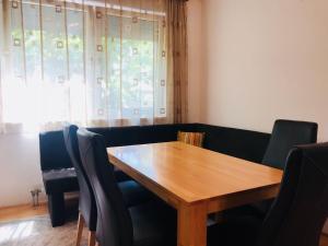 a dining room with a wooden table and chairs at Ilidza Apartments in Sarajevo +3 photos