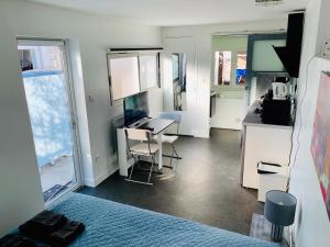 ヌイイ・プレザンスにあるVilla Florianのベッド、デスク、キッチンが備わる客室です。