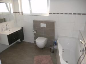 a bathroom with a tub and a toilet and a sink at Ferienwohnung Bernkastel-Kues - Alte Rebschule in Bernkastel-Kues +11 photos