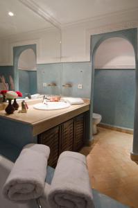 y baño con lavabo, bañera y espejo. en Palais Riad Berbère en Marrakech