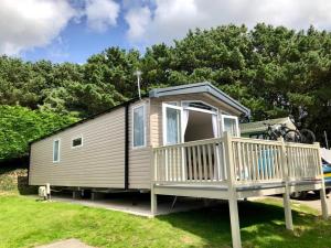 a tiny house with a porch and a deck at Newquay Blue Water in Newquay