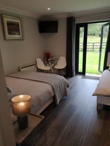 1 dormitorio con 1 cama, mesa y sillas en Tudor Lodge Guest Accommodation en Bunratty