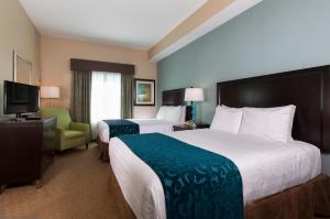 a hotel room with two beds and a television at Hawthorn Suites by Wyndham Lake Buena Vista, a staySky Hotel & Resort in Orlando