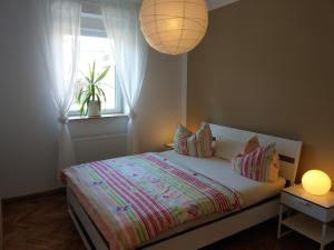 een slaapkamer met een bed met een raam en een lamp bij Storchennest an der Spree in Radinkendorf in Beeskow