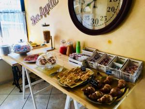a table with many different types of pastries and a clock at Hotel San Giorgio in Albisola Superiore