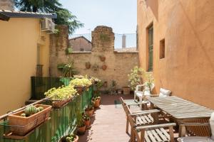 an outdoor patio with tables and chairs and potted plants at Petroni 38 by Studio Vita in Bologna