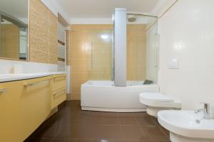 a bathroom with a tub and a toilet and a sink at Petroni 38 by Studio Vita in Bologna +34 photos