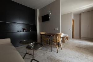 un soggiorno con tavolo, sedie e divano di Chacón Apartments & Suites a Estepona