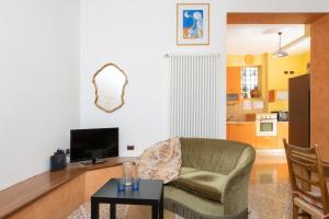 a living room with a chair and a television at Petroni 38 by Studio Vita in Bologna