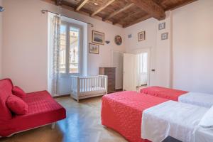 1 dormitorio con 2 camas, sofá y ventana en Petroni 38 by Studio Vita, en Bolonia