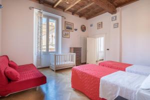 a bedroom with two beds and a couch and a window at Petroni 38 by Studio Vita in Bologna