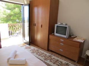 een slaapkamer met een bed en een tv op een dressoir bij Apartments and Rooms Rogosic in Hvar