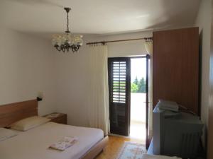 a bedroom with a bed and a chandelier at Apartments and Rooms Rogosic in Hvar