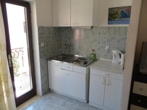 a kitchen with white cabinets and a sink at Apartments and Rooms Rogosic in Hvar +41 photos