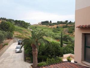 a palm tree and a car parked on a street at B&B Catanzaro lido La collina dei poeti in Catanzaro Lido