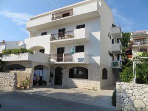 a white building with two balconies on a street at Apartments and Rooms Rogosic in Hvar