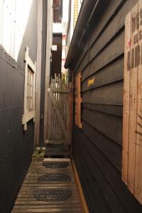 a narrow alley with a wooden wall and a building at Palafito Ayün in Castro